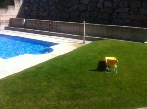 una silla sentada en el césped junto a una piscina en apartamento el mirador en Ezcaray