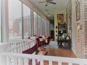 a room with a table and chairs and windows at Bazsinsky House in Vicksburg