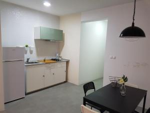 a kitchen with a black table and a refrigerator at Casa Io - Djeu in Mindelo