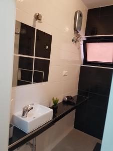 a bathroom with a sink and a mirror at Casa Io - Djeu in Mindelo