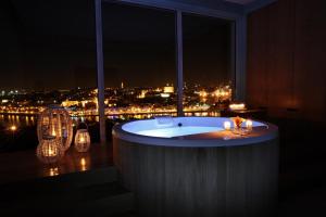a bath tub in a room with a view of a city at The Yeatman in Vila Nova de Gaia