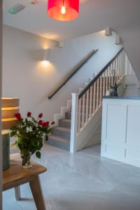 uma escada numa casa com um vaso de flores sobre uma mesa em Sheedy's Doolin em Doolin