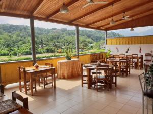 a restaurant with tables and chairs and a view at Residencial Mira Rio in Santo António