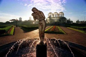 a statue of a man holding a child in a fountain at Minha casa é sua casa in Curitiba