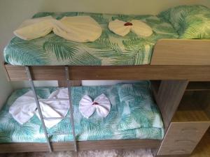 a bunk bed with towels and bows on it at Minha casa é sua casa in Curitiba
