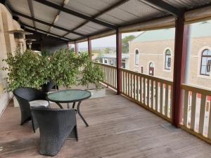 a patio with a table and chairs on a balcony at Balcony On Sixth Lodge in Murray Bridge