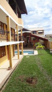 un patio de un edificio con piscina y césped en Dorado Hotel, en Cobija