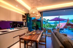 a kitchen and living room with a table and a couch at Patong Heights in Patong Beach