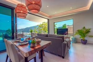 a living room with a table and a couch at Patong Heights in Patong Beach