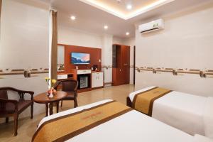 a hotel room with two beds and a table at Phuc Ngoc Hotel in Ap Rạch Soi