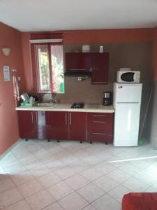 a kitchen with brown cabinets and a white refrigerator at Coin tranquille in Sainte-Anne