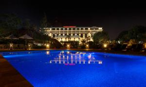 un edificio con piscina azul por la noche en Hotel Shanker-Palatial Heritage Kathmandu en Katmandú