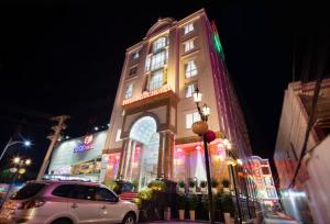 een auto geparkeerd voor een gebouw met neonlichten bij Phuc Ngoc Hotel in Ap Rạch Soi