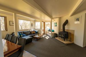 a living room with a couch and a stove at Wedgetail in Dinner Plain