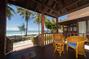 - une terrasse couverte avec des chaises et une table et une vue sur la plage dans l'établissement Sutera @ Mantanani Island Resort & Spa, à Île Mantanani