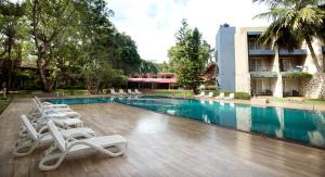 una piscina con sedie a sdraio accanto a un edificio di Miridiya Lake Resort a Anuradhapura