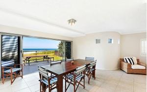 a dining room with a table and chairs and the ocean at BEACHFRONT Beauty! in Gold Coast