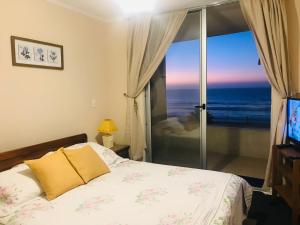 1 dormitorio con cama y vistas al océano en Oceanic Playa La Serena, en La Serena