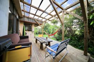 a screened in porch with a couch and a table at hamaca117 in Motobu