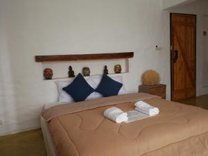 a bedroom with a large bed with blue pillows at Baantidnam in Ban Thung Tho