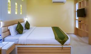 um quarto com uma cama e uma televisão na parede em Treebo Trend Oasis Cuttack Puri em Bhubaneshwar