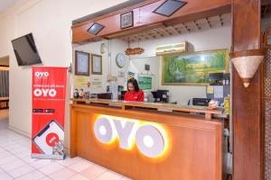 a woman sitting at a counter in a fast food restaurant at OYO 348 Hotel Dieng Permai in Yogyakarta