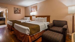 a hotel room with two beds and a chair at SureStay Hotel by Best Western Tehachapi in Tehachapi +11 photos