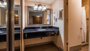 a bathroom with a large mirror and a sink at SureStay Hotel by Best Western Tehachapi in Tehachapi