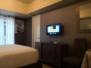 a bedroom with a bed and a flat screen tv at Centrio Tower Beside Ayala Studio Unit with Balcony 23 in Cagayan de Oro