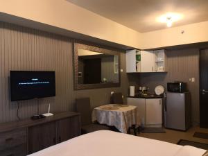 Zimmer mit einem Bett und einer Küche mit einem TV in der Unterkunft Centrio Tower Beside Ayala Studio Unit with Balcony 23 in Cagayan de Oro
