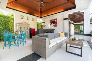 a living room with a couch and chairs and a table at Jewels Villas Phuket in Bang Tao Beach
