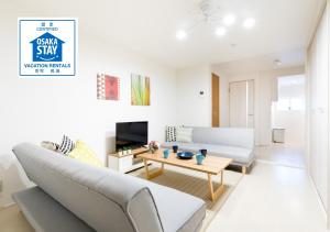 een woonkamer met een bank en een tafel bij Momodani House 501 in Osaka