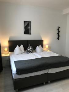 a bedroom with a large bed with two lamps at Liberty Hotel Cologne in Cologne