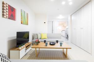a living room with a couch and a coffee table at Momodani House 501 in Osaka