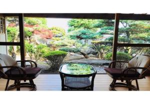 Kumano - House / Vacation STAY 9764 في كومانو: اطلالة على حديقة من شباك مع كراسي وطاولة