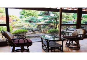 patio con mesa y sillas y vistas al jardín en Kumano - House / Vacation STAY 9764 en Kumano