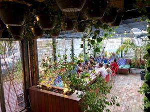 een groep mensen die aan een tafel in een tuin zitten bij Spinners Hostel in Perth