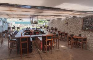 um restaurante com um bar com mesas e cadeiras de madeira em Zoola San Pedro Atitlan em San Pedro La Laguna