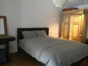 a bedroom with a bed and a wooden cabinet at SOHO Lodge Rasnov in Râşnov