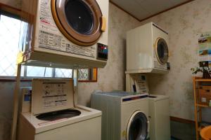 eine Waschküche mit Waschmaschine und Mikrowelle in der Unterkunft Pension Kongo Baru in Tokunoshima