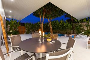 曾蒙海灘的住宿－Villa White Orchid，庭院内带蜡烛的餐桌