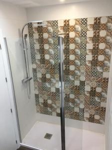 une salle de bain avec une douche avec une porte vitrée dans l'établissement Piso moderno en casco antiguo próximo a la playa, à Alicante