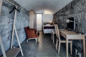 Zimmer mit einem Schreibtisch und einem Schlafzimmer mit einem Bett. in der Unterkunft Fårösunds Fästning in Fårösund