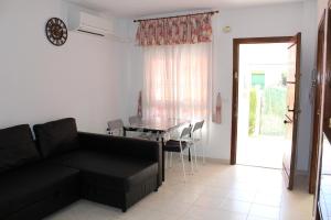 salon z czarną kanapą i stołem w obiekcie Geraneos Playa w mieście Torrevieja