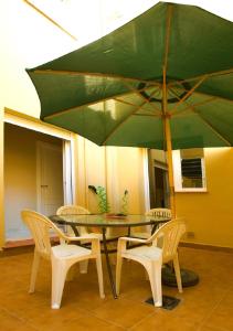 タリファにあるApartamento Del Rioの椅子と緑の傘が備わるテーブル