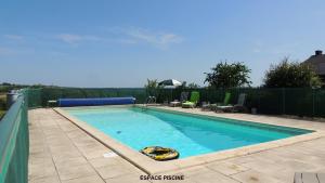 een zwembad in een tuin met een hek bij Gîte Layon 6 places Moulin de la Placette in Faye-dʼAnjou