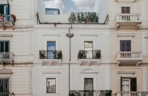 una facciata di un edificio bianco con finestre e balconi di Bacã Suites, Restaurant & Bar a Taranto