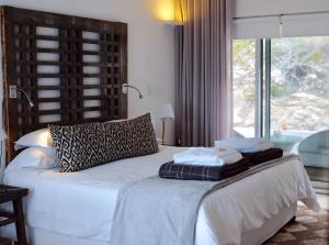 a bedroom with a large bed and a large window at Agulhas Ocean House in Agulhas