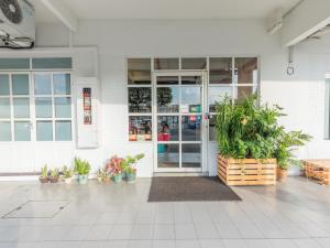 una entrada a un edificio con macetas delante en White Loft Hotel en Melaka