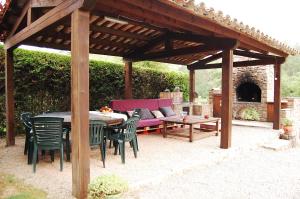 un pabellón de madera con mesa, sillas y banco en Cal Teulats - Masoveria, en Perafita